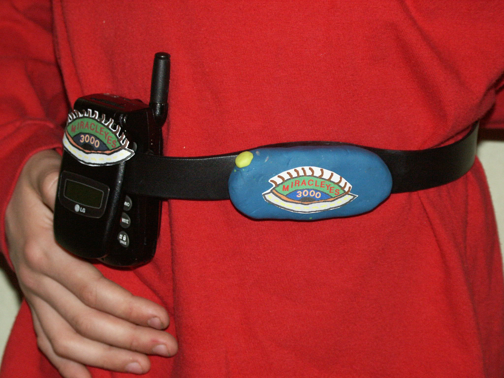 Photo of MiraclEyes belt and cell phone on user's waist.