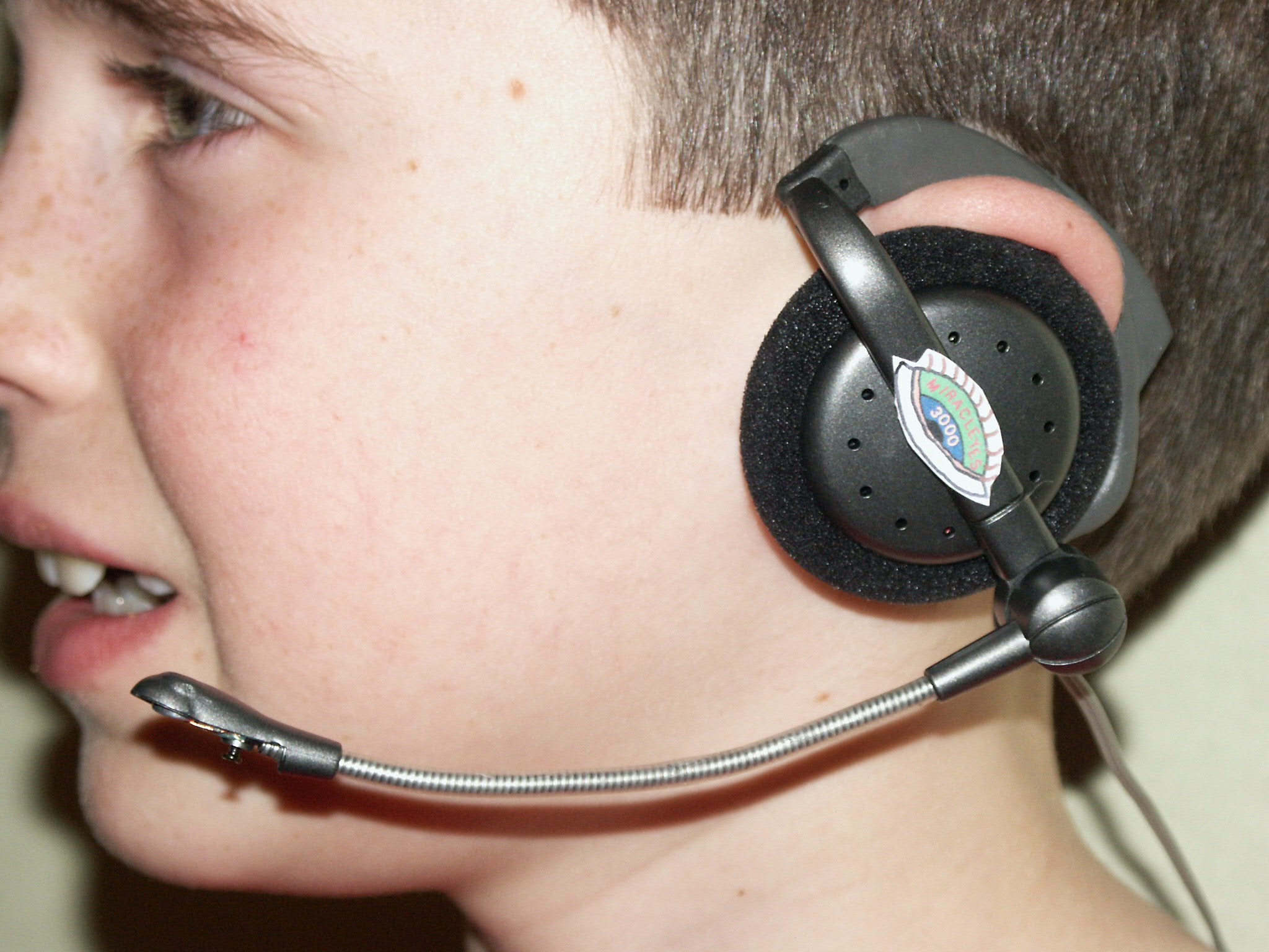 Photo of MiraclEyes earpiece and microphone on user's head.